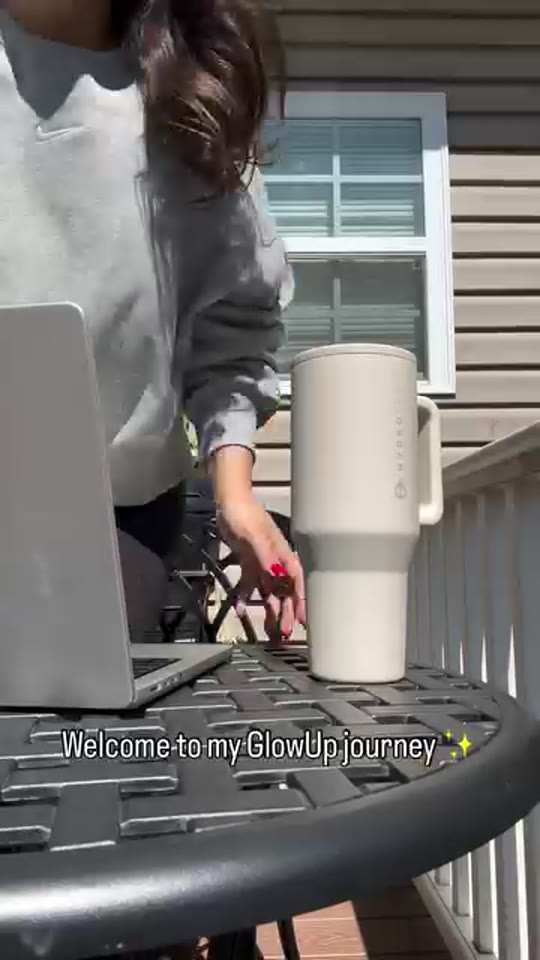 Meg at a patio table with her laptop and water bottle